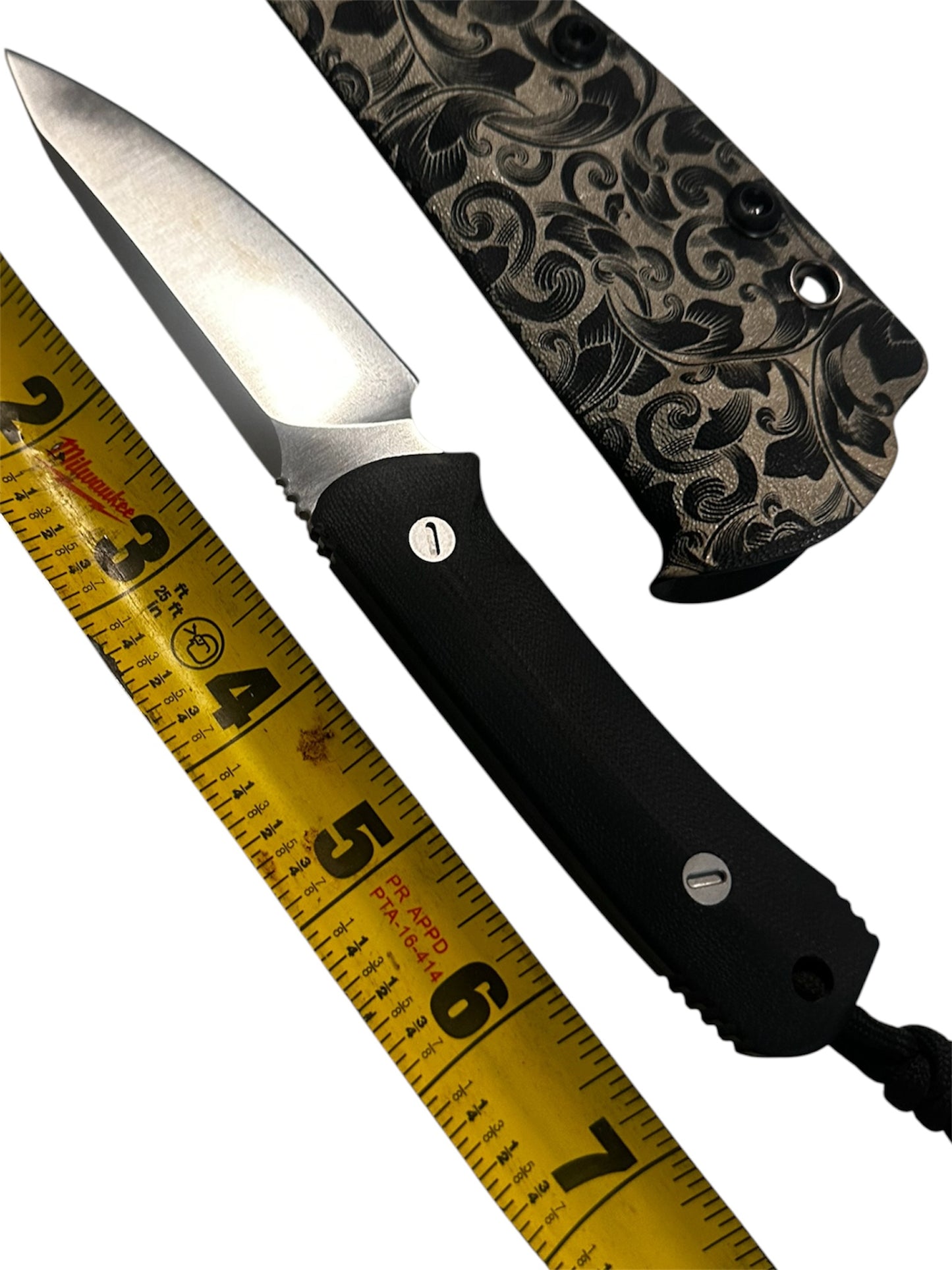 Compact 7-inch D2 fixed blade featuring black Micarta scales, custom floral engraved Kydex sheath, black paracord lanyard, and complimentary RockinEDC Steel Wax.