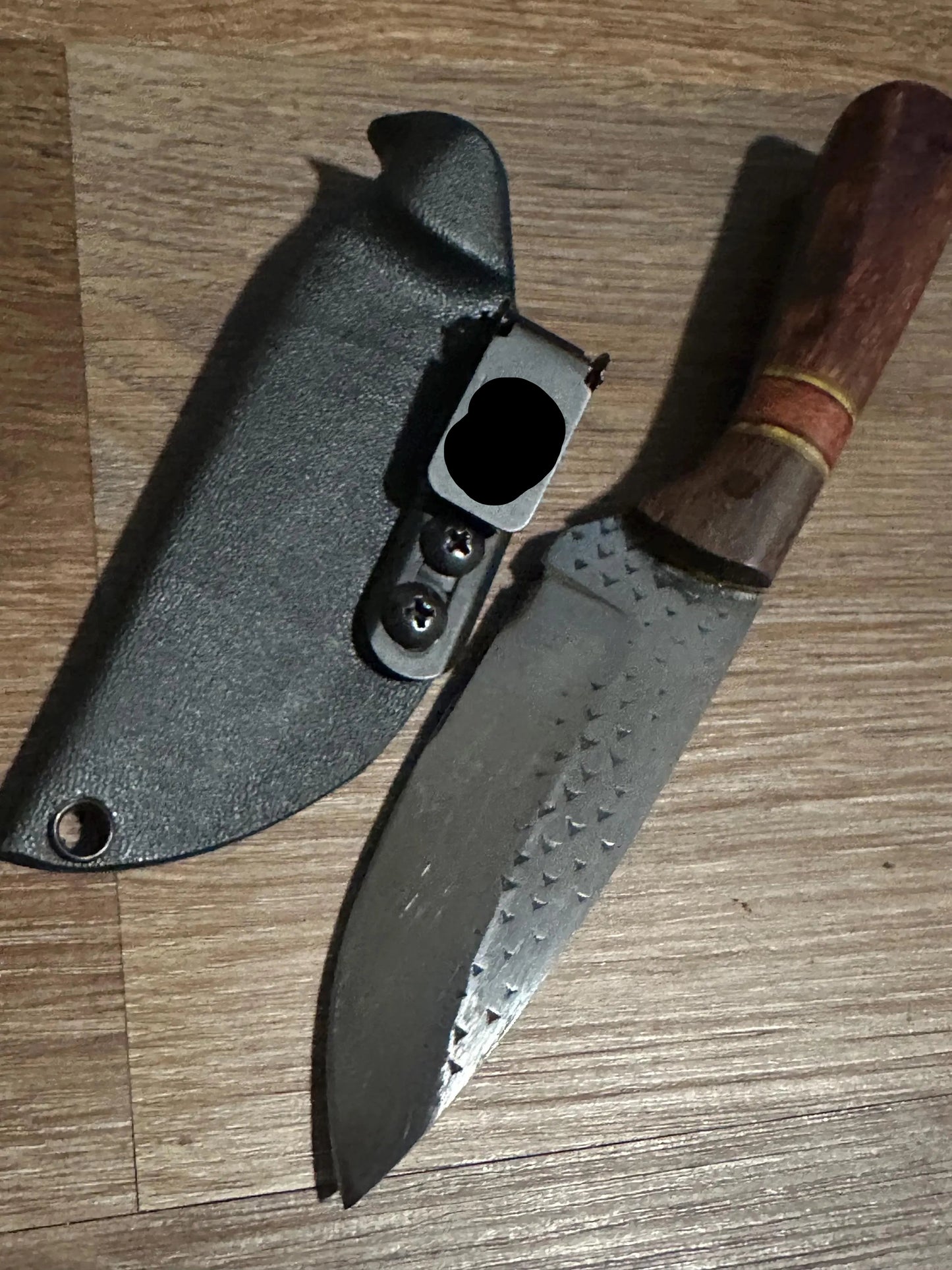 Forked blade knife with wooden handle and sheath on a wooden surface